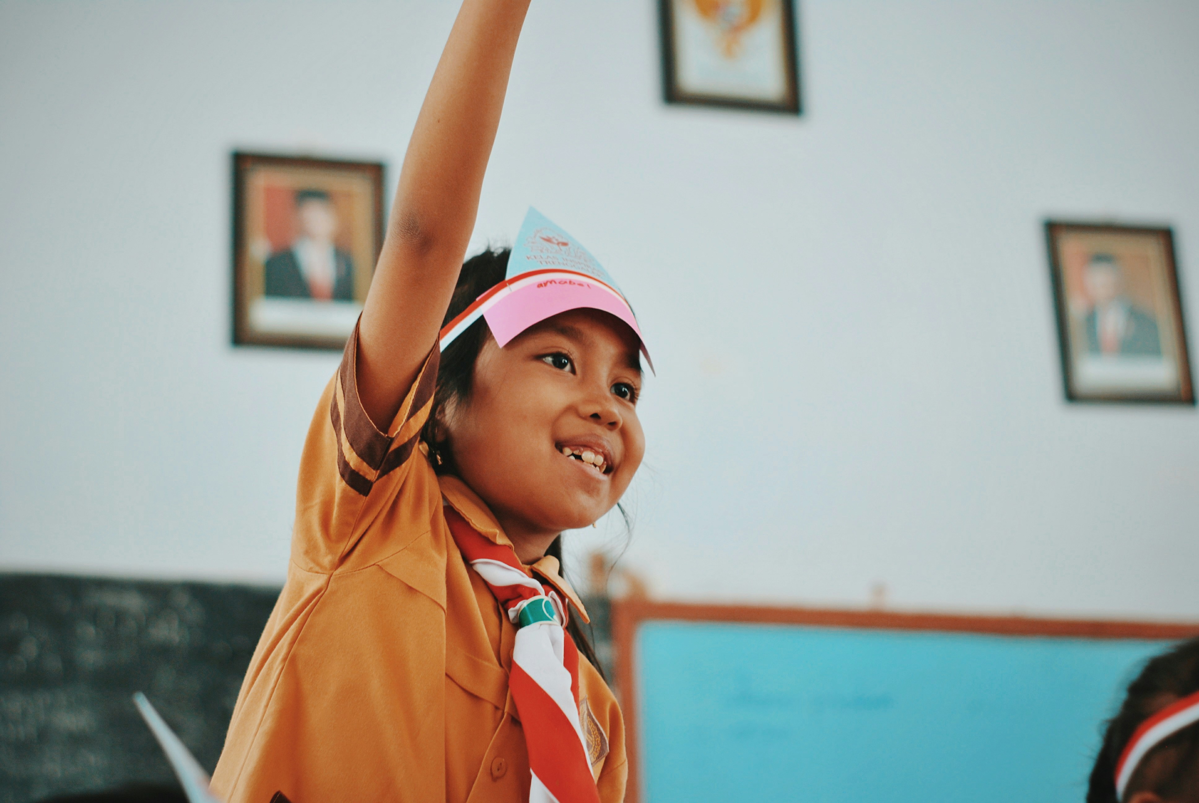 Child raising hand in study class